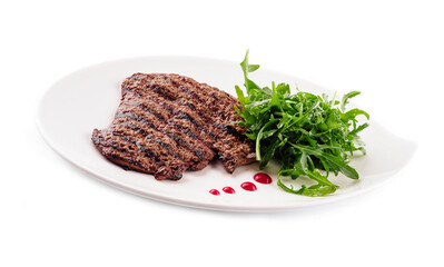 Ribeye steak with arugula on white plate