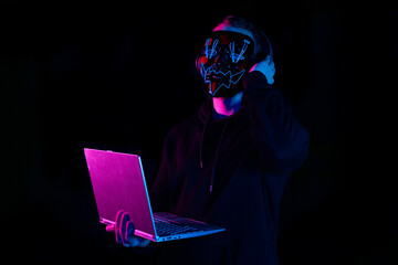 DJ with halloween led mask in a party club in black background. Purge film mask