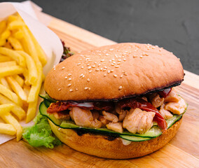 Burger with fries on wooden rustic Board