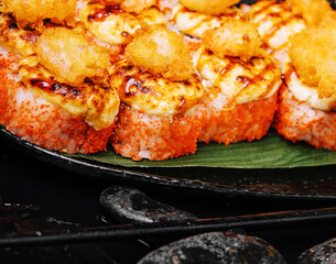 Warm Sushi Roll with Salmon and Cream Cheese served on a black board