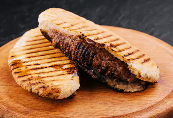 fried pita with pork steak on wooden tray