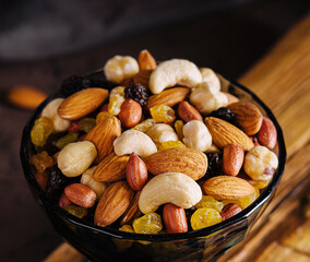 Bowl with mixed organic nuts on wooden board