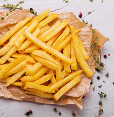 Golden yummy deep french fries on kraft baking sheet paper