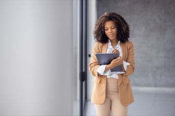 Smiling african-american businesswoman using digital tablet in office
