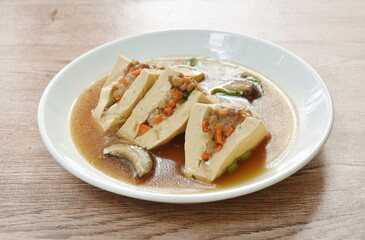 steamed white tofu stuffed mashed pork in gravy sauce on plate