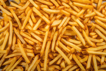 French fries as background, fried potato sticks, golden fries, roasted potatoes, finger chips, french fries texture, frites. Fast food, junk street food 