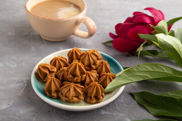 Homemade soft caramel fudge candies on gray concrete, side view,