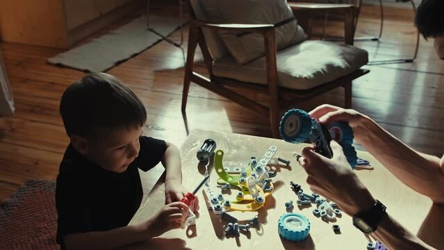 Father and son play constructor. Games at home with parents.