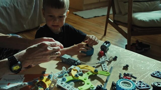 Father and son play constructor. Games at home with parents.