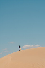 Woman with a dog on Patara Beach Turkey, clouds above.