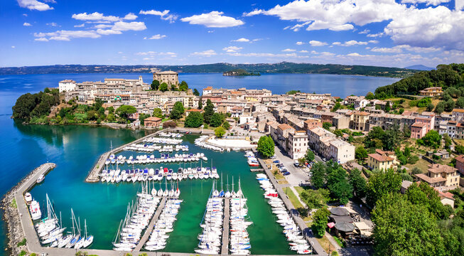 Bolsena Lake Italy 6k aerial panorama of Capodimonte medieval village on peninsula. Scenic drone view of luxury yacht marina and ancient castle in Viterbo province. Beautiful Lazio travel destination