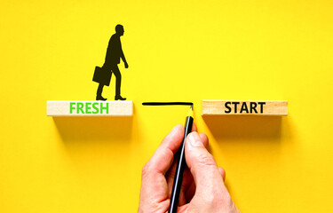 Fresh start and motivational symbol. Concept words Fresh start on wooden block. Beautiful yellow table yellow background. Businessman hand. Business motivational and Fresh start concept. Copy space.