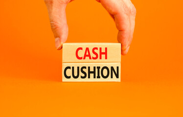 Cash cushion symbol. Concept words Cash cushion on beautiful wooden block. Beautiful orange table orange background. Businessman hand. Business and Cash cushion concept. Copy space.