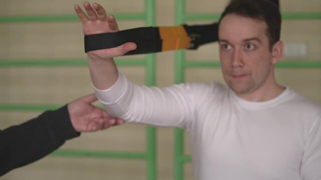 young caucasian man doing strength fitness using TRX loops in the gym, personal trainer watching a sporty young man.close up.slow motion video. High quality Full HD video recording Generative AI