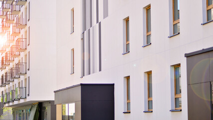 Fototapeta premium Modern apartment buildings on a sunny day with a blue sky. Facade of a modern apartment building. Contemporary residential building exterior in the daylight. 