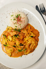 Red curry dish with seafood, chicken and rice. Top view