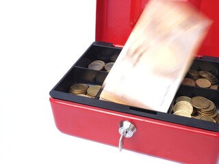 Red money box witn coins and flying euro bills