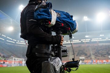 Cameraman behind playing field during soccer match in the rain
