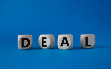 Deal symbol. Concept word Deal on wooden cubes. Beautiful blue background. Business and Deal concept. Copy space.