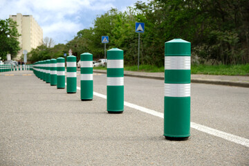A lot of restrictive green plastic poles to regulate traffic in the city.
