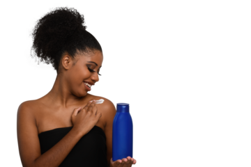 a woman applying moisturizing cream to her skin, smiling while holding a bottle demonstrating skin care
