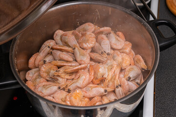 A lot of big shrimps, prawns are being cooked in the cooker 