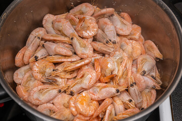 A lot of big shrimps, prawns are being cooked in the cooker 