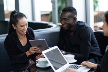 Group of Diversity people Businessman and businesswoman sitting at table in coffee shop and discuss business plan. Teamwork, business meeting. Freelancers working indoors.