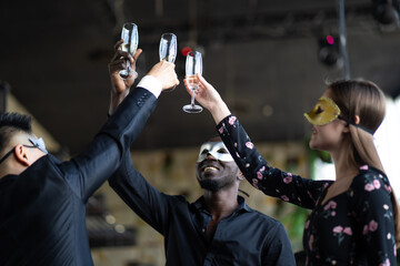 Masquerade party. Beautiful women and men wearing fantasy mask. Company employee enjoy drinking in mask party  together indoors celebration