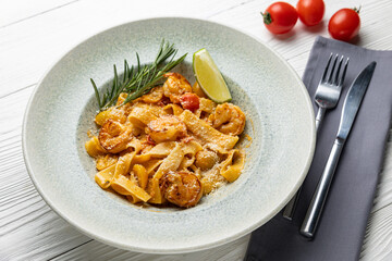 delicious pasta in a plate on a white wooden table. close-up
