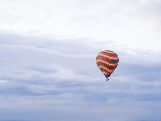 Obraz premium Process of launching many colored beautiful balloons into air in Cappadocia in mountains early at dawn. Filling balloon with hot air from burner, preparing basket. Excursion,flight for tourists above