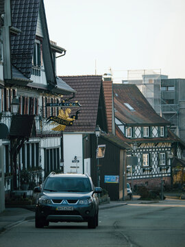 Achern, Germany - Feb 10, 2023: A peaceful residential Achern, Baden-Wurttemberg region of Germany featuring ancient buildings and infrastructure with a cute street houses, cars and a Mitsubishi SUV.