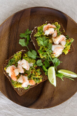 plate of toasts with guacamole and shrimps on the table