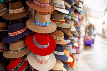 Traditionelle peruanische Hüte auf einem Markt in Pisac nahe Cusco. - obrazy, fototapety, plakaty
