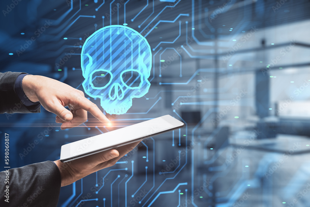 Poster close up of male hands using tablet with glowing skull hologram on blurry office interior background