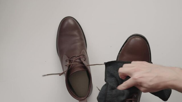 Man cleaning brown leather boots