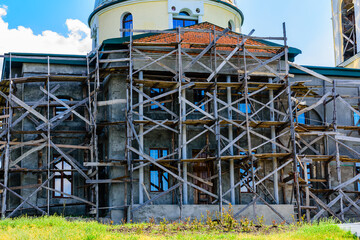 Fototapeta na wymiar Reconstruction of the old orthodox church in ukrainian countryside. Wooden scaffolding