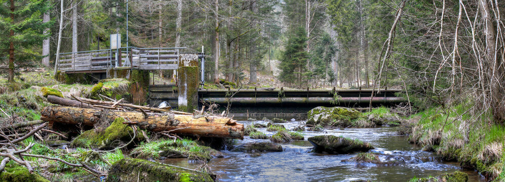 A small weir that dams up the river GroÃŸer Regen near the town of Bayerisch Eisenstein in the Bavarian Forest in order to generate electricity with the power of the steadily flowing water.