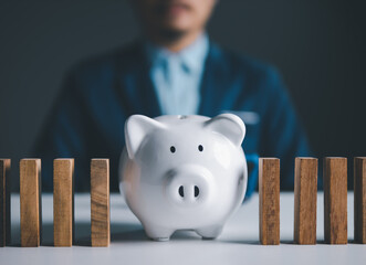 Businessman holding piggy bank full of money, representing savings and financial investment