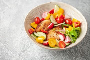 Chicken fillet grill with vegetable salad in a bowl on the table