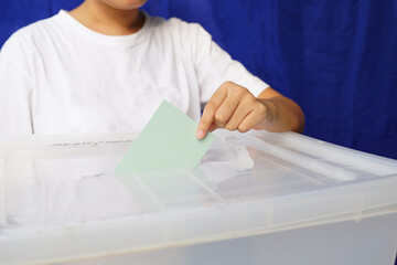 Thai people cast their ballot papers into the box to vote for members of the House of...
