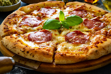 Circle pepperoni pizza with mozzarella cheese on wooden table
