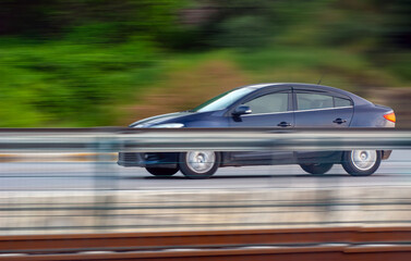 Fototapeta na wymiar Car driving fast motion on highway side view