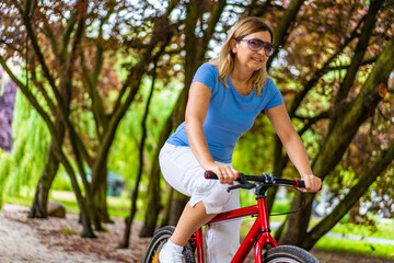 Woman riding bicycle in city park
