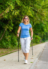 Nordic walking - woman training in city park
