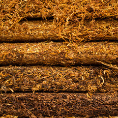 Background texture of tobacco finely chopped cooked processed product. Close-up of tobacco for rolling cigarettes. Place for text or background. Copy paste space for your brand or product and packagin