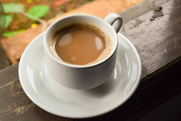 Photo of a cup of coffee milk. White ceramic cup. Flat lay