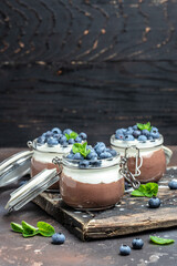 Parfait with blueberry, Delicious chocolate mousse or pudding with whipped cream. vertical image. top view. place for text