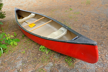 Red kayak on shore of Messalonskee lake. State of Maine