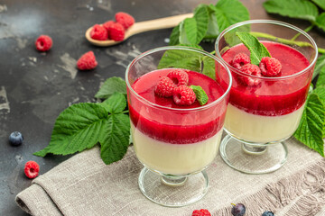 Raspberry sorbet with whipped cream and mint. Italian dessert on a dark background in small jars. place for text
